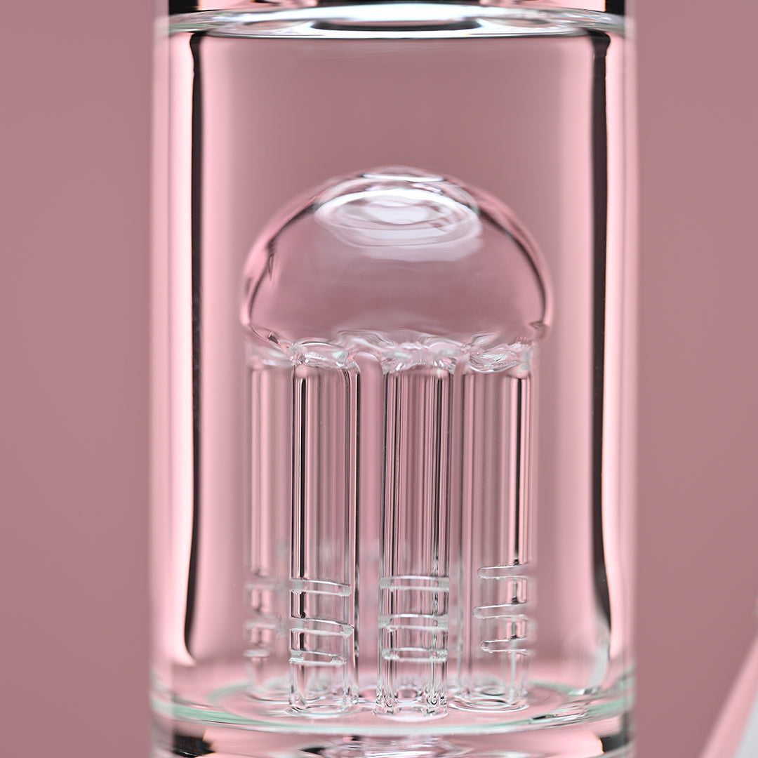 Close-up view of the eight-arm percolator inside a clear glass beaker bong with pink accents, set against a soft pink background. The image focuses on the intricate details and craftsmanship of the percolator, highlighting the quality and precision of the glasswork.