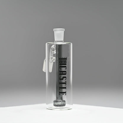 A clear glass ash catcher featuring the brand name "CASTLE" in bold black letters on the side, with a black showerhead percolator. The ash catcher is positioned against a neutral grey background, which enhances the sleek and modern design of the piece. The transparent glass and precise craftsmanship are highlighted, giving the ash catcher a minimalist and sophisticated appearance.