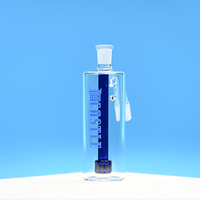 A glass ash catcher featuring the brand name Castle in bold blue letters on the side, with a matching blue matrix percolator. The ash catcher is positioned against a vibrant blue background, which accentuates the deep blue color of the percolator and the branding. The transparent glass design and clean lines are highlighted, showcasing the modern and sleek craftsmanship of the piece.