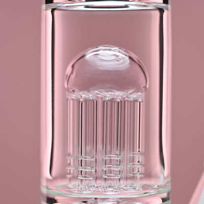 Close-up view of the eight-arm percolator inside a clear glass beaker bong with pink accents, set against a soft pink background. The image focuses on the intricate details and craftsmanship of the percolator, highlighting the quality and precision of the glasswork.